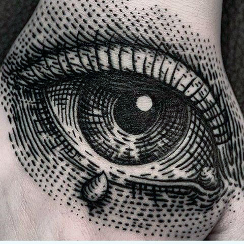 black dotted design eye tattoo on males hand